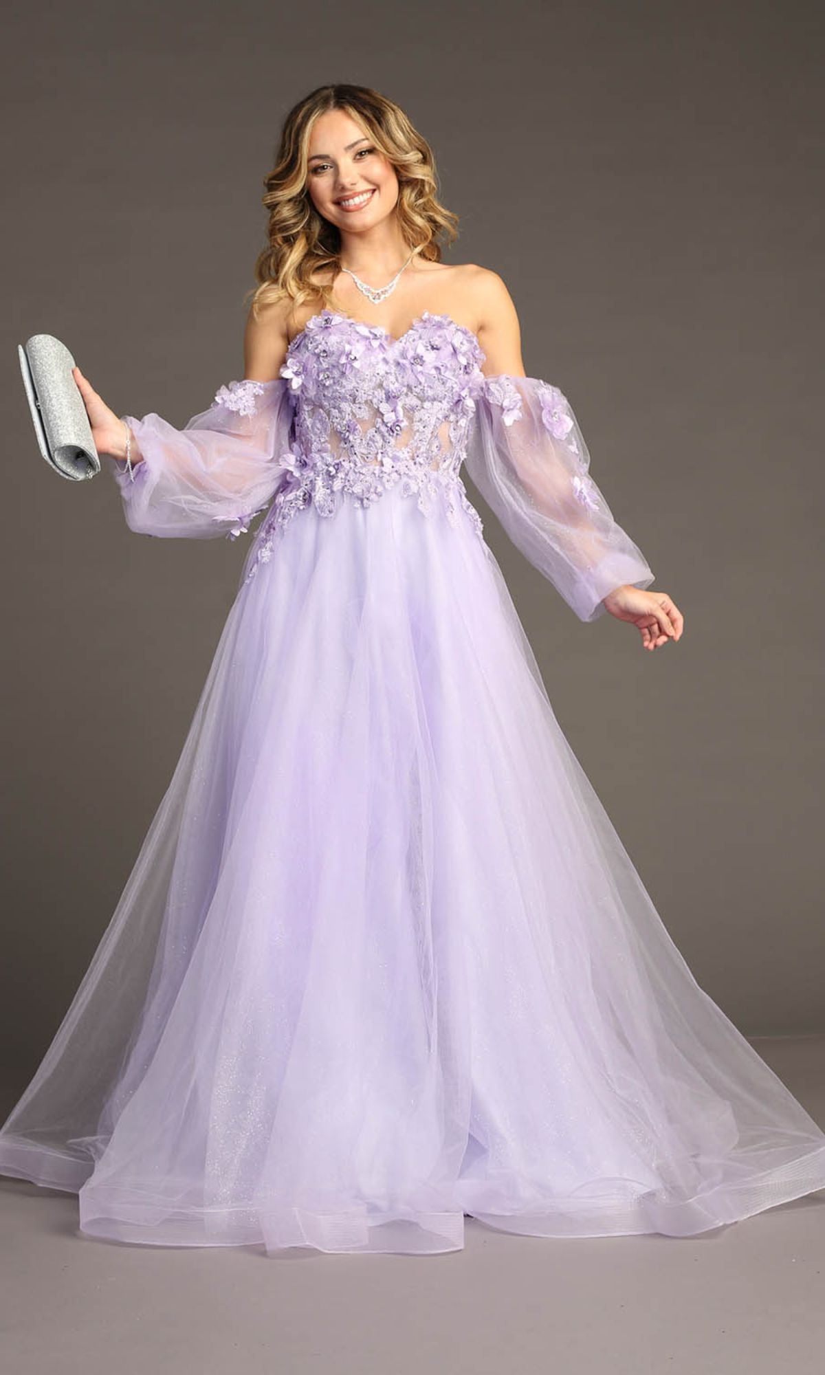Woman in the Chicas CHF3096 long sleeve, long prom ball gown holding a silver clutch against a plain background.
